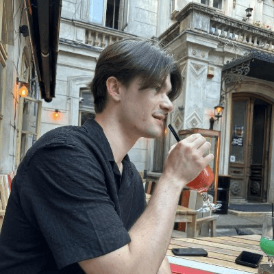 Michał Rostkowski sipping a drink at a street café